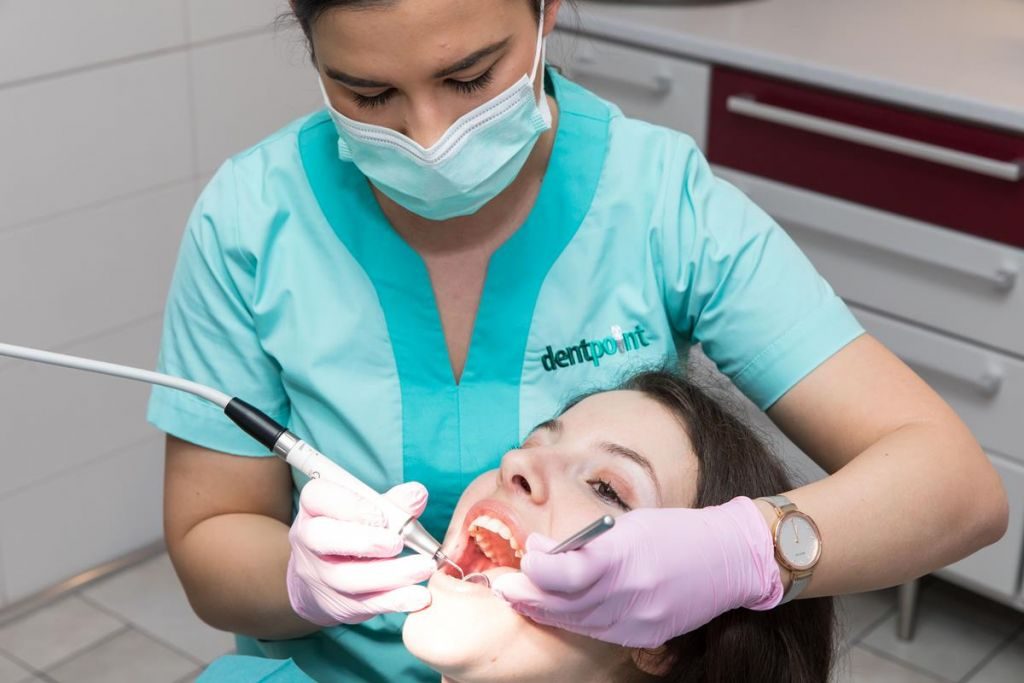 A dentálhigiénikus kezelést ad egy páciensnek.